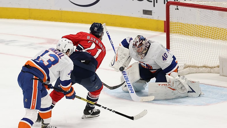 Mar 16, 2021; Washington, District of Columbia, USA;  New York Islanders goaltender Semyon Varlamov (40) makes a save on Washington Capitals right wing Garnet Hathaway (21) as Islanders center Mathew Barzal (13) defends in the second period at Capital One Arena. Mandatory Credit: Geoff Burke-USA TODAY Sports