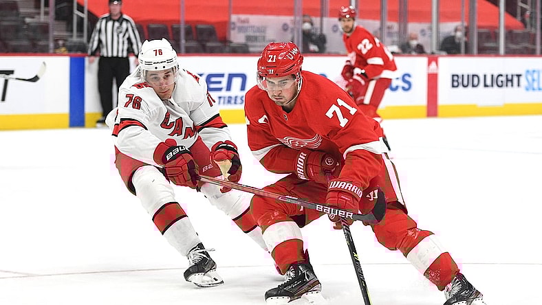 Mar 16, 2021; Detroit, Michigan, USA; Detroit Red Wings center Dylan Larkin (71) skates the puck up ice against Carolina Hurricanes defenseman Brady Skjei (76) during the second period at Little Caesars Arena. Mandatory Credit: Tim Fuller-USA TODAY Sports