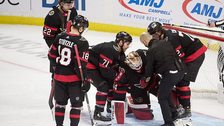 Mar 17, 2021; Ottawa, Ontario, CAN; Ottawa Senators goalie Joey Daccord (34) is helped off the ice after getting injured in the third period against the Vancouver Canucks  at the Canadian Tire Centre. Mandatory Credit: Marc DesRosiers-USA TODAY Sports