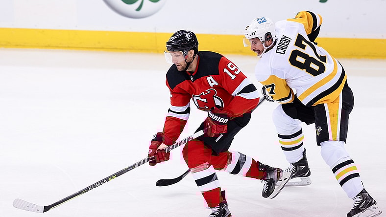 Mar 18, 2021; Newark, New Jersey, USA; New Jersey Devils center Travis Zajac (19) skates with the puck as Pittsburgh Penguins center Sidney Crosby (87) chases during the first period at Prudential Center. Mandatory Credit: Vincent Carchietta-USA TODAY Sports