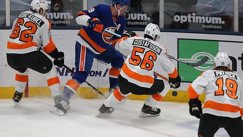 Mar 18, 2021; Uniondale, New York, USA; New York Islanders center Brock Nelson (29) fights for the puck against Philadelphia Flyers right wing Nicolas Aube-Kubel (62) and defenseman Erik Gustafsson (56) during the first period at Nassau Veterans Memorial Coliseum. Mandatory Credit: Brad Penner-USA TODAY Sports