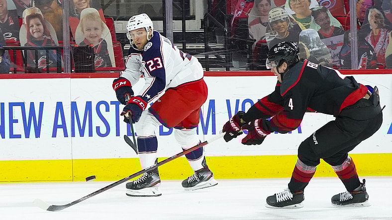 Mar 18, 2021; Raleigh, North Carolina, USA;  Columbus Blue Jackets Stefan Matteau (23) shoots against Carolina Hurricanes defenseman Haydn Fleury (4) during the first period at PNC Arena. Mandatory Credit: James Guillory-USA TODAY Sports