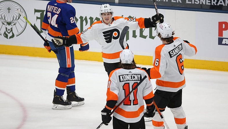 Mar 18, 2021; Uniondale, New York, USA; Philadelphia Flyers left wing Oskar Lindblom (23) celebrates his game winning goal against the New York Islanders with right wing Travis Konecny (11) and defenseman Travis Sanheim (6) in front of Islanders defenseman Scott Mayfield (24) during the third period at Nassau Veterans Memorial Coliseum. Mandatory Credit: Brad Penner-USA TODAY Sports