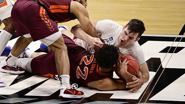Mar 19, 2021; Indianapolis, Indiana, USA; Florida Gators forward Colin Castleton (12) dives for a loose ball against Virginia Tech Hokies forward Keve Aluma (22) during the first round of the 2021 NCAA Tournament at Hinkle Fieldhouse. Mandatory Credit: Marc Lebryk-USA TODAY Sports