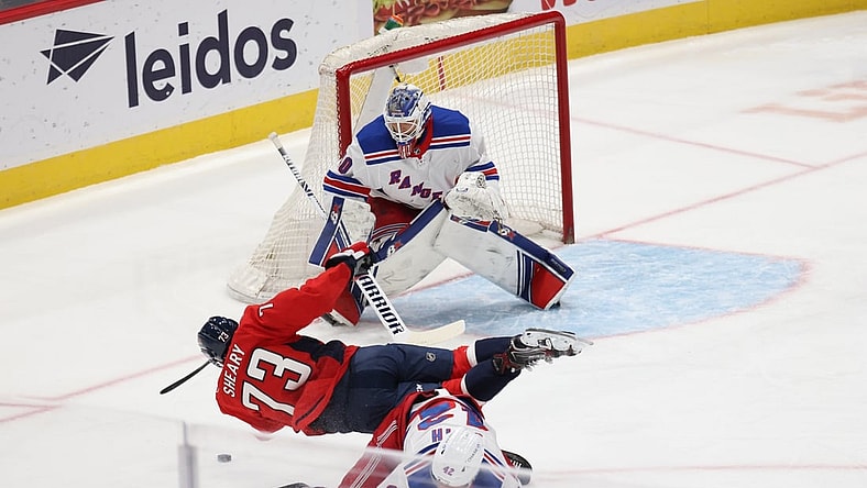 Mar 19, 2021; Washington, District of Columbia, USA; Washington Capitals left wing Conor Sheary (73) is checked by New York Rangers defenseman Brendan Smith (42) while attempting a shot on Rangers goaltender Alexandar Georgiev (40) in the first period at Capital One Arena. Mandatory Credit: Geoff Burke-USA TODAY Sports