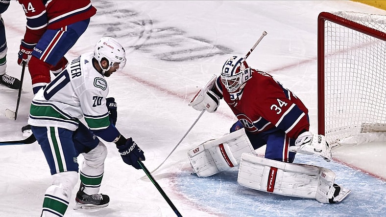 Mar 19, 2021; Montreal, Quebec, CAN; Vancouver Canucks center Brandon Sutter (20) shots the puck against Montreal Canadiens goaltender Jake Allen (34) during the first period at Bell Centre. Mandatory Credit: Jean-Yves Ahern-USA TODAY Sports