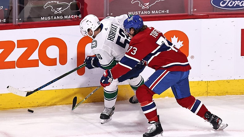 Mar 19, 2021; Montreal, Quebec, CAN; Vancouver Canucks center Bo Horvat (53) and Montreal Canadiens right wing Tyler Toffoli (73) battle for the puck during the first period at Bell Centre. Mandatory Credit: Jean-Yves Ahern-USA TODAY Sports