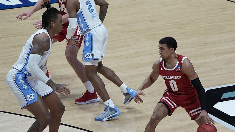 Mar 19, 2021; West Lafayette, Indiana, USA; Wisconsin Badgers guard D'Mitrik Trice (0) dribbles the ball upcourt against North Carolina Tar Heels forward Armando Bacot (left) during the second half in the first round of the 2021 NCAA Tournament at Mackey Arena. Mandatory Credit: Mike Dinovo-USA TODAY Sports