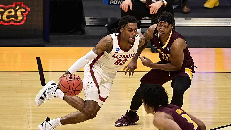 Mar 20, 2021; Indianapolis, Indiana, USA; Alabama Crimson Tide guard John Petty Jr. (23) dribbles against Iona Gaels guard Isaiah Ross (20) during the first round of the 2021 NCAA Tournament at Hinkle Fieldhouse. Mandatory Credit: Marc Lebryk-USA TODAY Sports