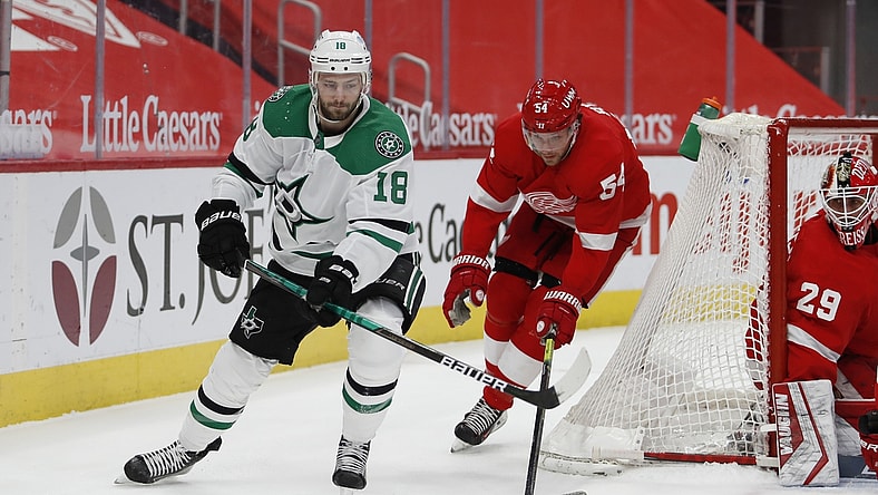 Mar 20, 2021; Detroit, Michigan, USA; Dallas Stars center Jason Dickinson (18) passes the puck against Detroit Red Wings right wing Bobby Ryan (54) during the first period at Little Caesars Arena. Mandatory Credit: Raj Mehta-USA TODAY Sports