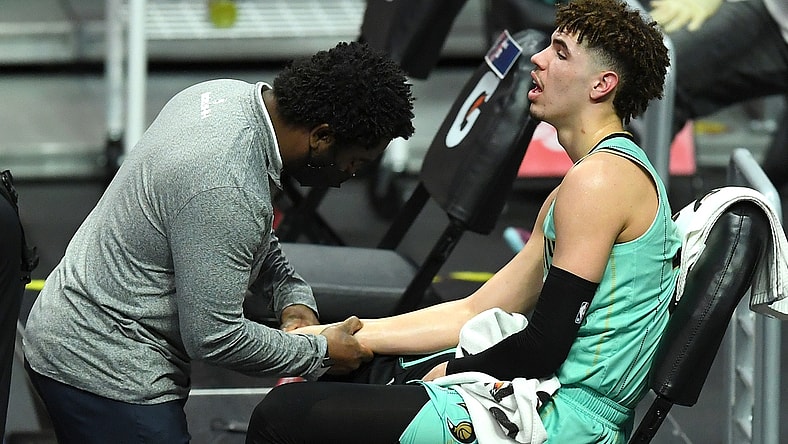 Mar 20, 2021; Los Angeles, California, USA; Charlotte Hornets team trainer checks the wrist of guard LaMelo Ball (2) in the second half of the game against the Los Angeles Clippers at Staples Center. Mandatory Credit: Jayne Kamin-Oncea-USA TODAY Sports
