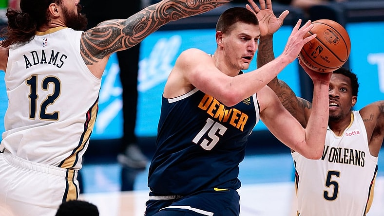Mar 21, 2021; Denver, Colorado, USA; Denver Nuggets center Nikola Jokic (15) looks to pass the ball under pressure from New Orleans Pelicans center Steven Adams (12) and guard Eric Bledsoe (5) in the second quarter at Ball Arena. Mandatory Credit: Isaiah J. Downing-USA TODAY Sports