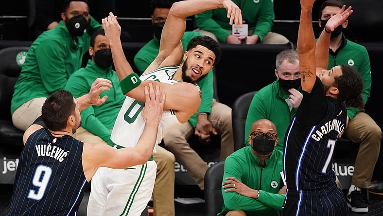 Mar 21, 2021; Boston, Massachusetts, USA; Boston Celtics forward Jayson Tatum (0) passes the ball against Orlando Magic guard Michael Carter-Williams (7) and center Nikola Vucevic (9) in the third quarter at TD Garden. Mandatory Credit: David Butler II-USA TODAY Sports