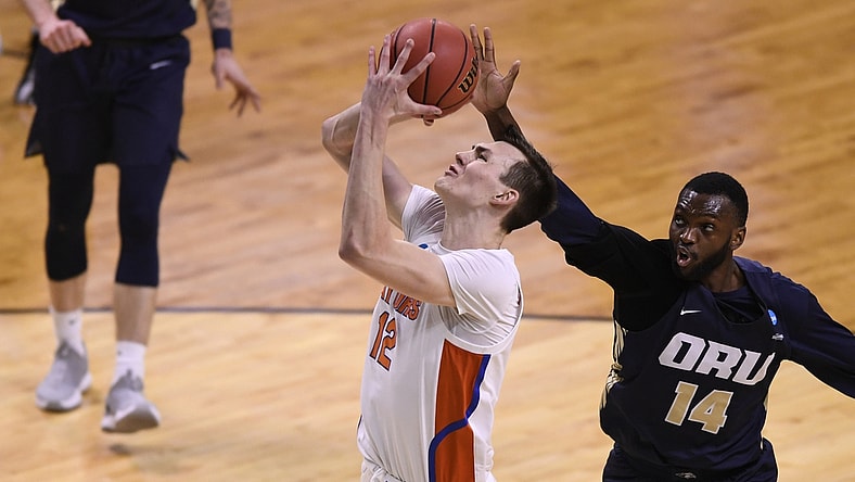 Mar 21, 2021; Indianapolis, Indiana, USA; Oral Roberts Golden Eagles forward DeShang Weaver (14) attempts to block a shot from Florida Gators forward Colin Castleton (12) in the second half in the second round of the 2021 NCAA Tournament at Indiana Farmers Coliseum. Mandatory Credit: Doug McSchooler-USA TODAY Sports