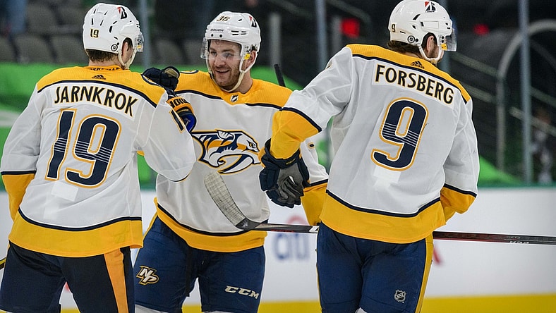 Mar 21, 2021; Dallas, Texas, USA; Nashville Predators center Calle Jarnkrok (19) and defenseman Jeremy Davies (38) and left wing Filip Forsberg (9) celebrate the win over the Dallas Stars at the American Airlines Center. Mandatory Credit: Jerome Miron-USA TODAY Sports