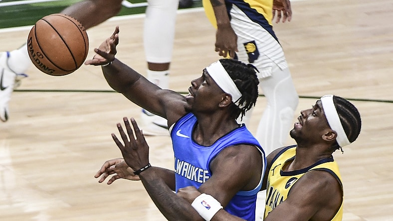 Mar 22, 2021; Milwaukee, Wisconsin, USA; Milwaukee Bucks guard Jrue Holiday is fouled by Indiana Pacers guard Caris LeVert (22) in the third quarter at Fiserv Forum. Mandatory Credit: Benny Sieu-USA TODAY Sports