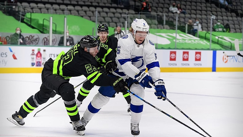 Mar 23, 2021; Dallas, Texas, USA; Dallas Stars defenseman Esa Lindell (23) and Tampa Bay Lightning defenseman Andreas Borgman (5) chase the puck during the first period at the American Airlines Center. Mandatory Credit: Jerome Miron-USA TODAY Sports