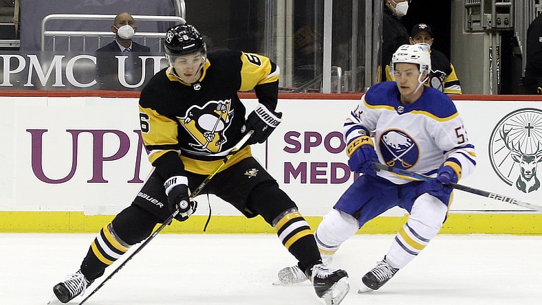 Mar 24, 2021; Pittsburgh, Pennsylvania, USA; Pittsburgh Penguins defenseman John Marino (6) handles the puck against Buffalo Sabres left wing Jeff Skinner (53) during the first period at PPG Paints Arena. Mandatory Credit: Charles LeClaire-USA TODAY Sports