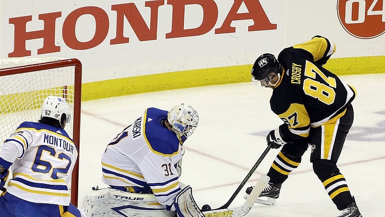 Mar 24, 2021; Pittsburgh, Pennsylvania, USA; Buffalo Sabres goaltender Dustin Tokarski (31) makes a save against Pittsburgh Penguins center Sidney Crosby (87) during the second period at PPG Paints Arena. Mandatory Credit: Charles LeClaire-USA TODAY Sports