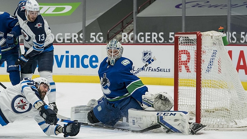 Mar 24, 2021; Vancouver, British Columbia, CAN; Vancouver Canucks goalie Thatcher Demko (35) makes a save on Winnipeg Jets forward Mathieu Perreault (85) in the first period at Rogers Arena. Mandatory Credit: Bob Frid-USA TODAY Sports