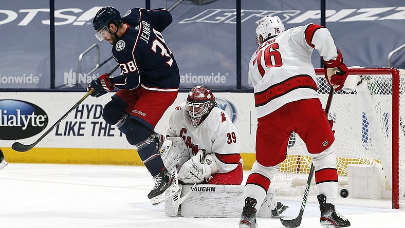 Mar 25, 2021; Columbus, Ohio, USA; Carolina Hurricanes goalie Alex Nedeljkovic (39) makes a save through he screen of Columbus Blue Jackets center Boone Jenner (38) during the first period at Nationwide Arena. Mandatory Credit: Russell LaBounty-USA TODAY Sports