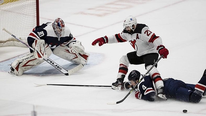 Mar 26, 2021; Washington, District of Columbia, USA; Washington Capitals defenseman Brenden Dillon (4) dives to knock the puck away from New Jersey Devils right wing Kyle Palmieri (21) in front of goaltender Ilya Samsonov (30) during the second period at Capital One Arena. Mandatory Credit: Scott Taetsch-USA TODAY Sports