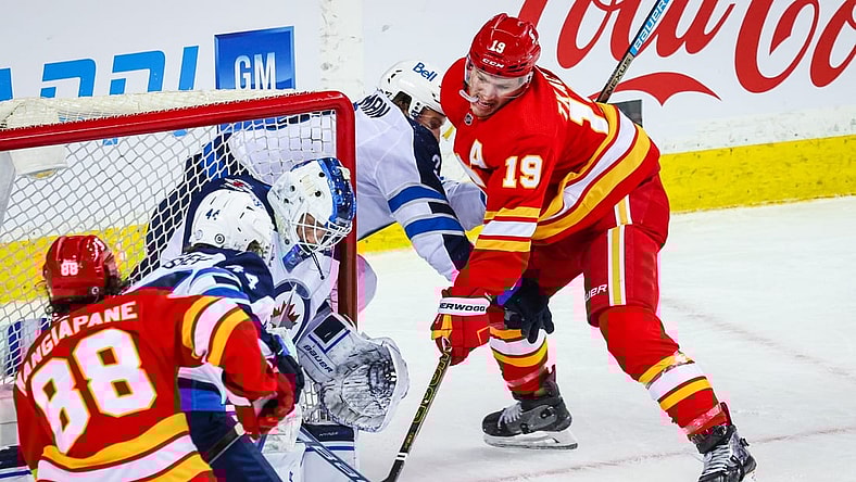 Mar 27, 2021; Calgary, Alberta, CAN; Calgary Flames left wing Matthew Tkachuk (19) moves in for a shot against Winnipeg Jets goaltender Laurent Brossoit (30) during the first period at Scotiabank Saddledome. Mandatory Credit: Sergei Belski-USA TODAY Sports