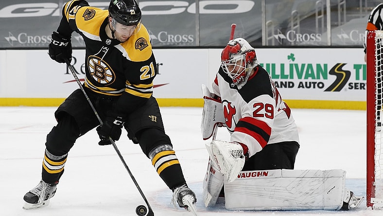Mar 28, 2021; Boston, Massachusetts, USA; Boston Bruins left wing Nick Ritchie (21) deflects a shot in front of New Jersey Devils goaltender Mackenzie Blackwood (29) during the third period at TD Garden. Mandatory Credit: Winslow Townson-USA TODAY Sports
