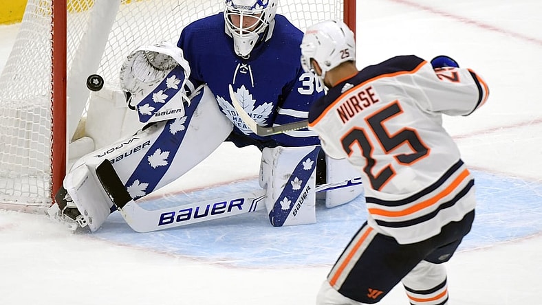 Mar 29, 2021; Toronto, Ontario, CAN; Edmonton Oilers defenseman Darnell Nurse (25) scores the game winning goal past Toronto Maple Leafs goalie Michael Hutchinson (30) in overtime at Scotiabank Arena. Mandatory Credit: Dan Hamilton-USA TODAY Sports