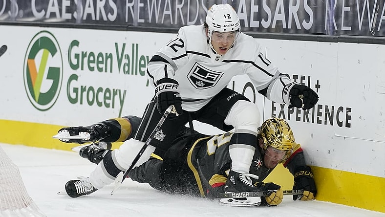 Mar 29, 2021; Las Vegas, Nevada, USA; Los Angeles Kings center Trevor Moore (12) knocks Vegas Golden Knights defenseman Zach Whitecloud (2) to the ice during the first period at T-Mobile Arena. Mandatory Credit: John Locher/POOL PHOTOS-USA TODAY Sports
