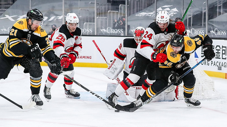 Mar 30, 2021; Boston, Massachusetts, USA; Boston Bruins left wing Nick Ritchie (21) and center David Krejci (46) and New Jersey Devils defenseman Ty Smith (24) battle for the puck during the first period at TD Garden. Mandatory Credit: Paul Rutherford-USA TODAY Sports