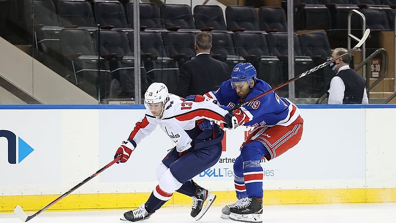 Mar 30, 2021; New York, New York, USA; Washington Capitals left wing Jakub Vrana (13) and New York Rangers defenseman K'Andre Miller (79) battle for the puck during a game at Madison Square Garden. Mandatory Credit: Al Bello/POOL PHOTOS-USA TODAY Sports