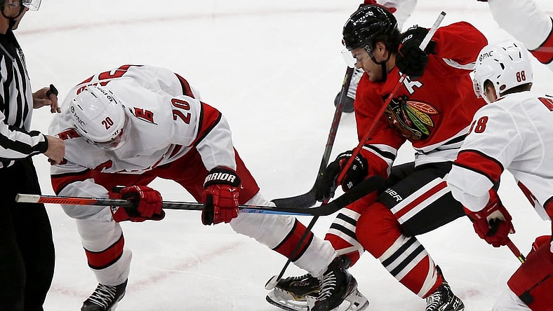 Mar 30, 2021; Chicago, Illinois, USA; Carolina Hurricanes center Sebastian Aho (20) battles for the puck with Chicago Blackhawks Alex DeBrincat (12) during the first period at United Center. Mandatory Credit: Eileen T. Meslar-USA TODAY Sports