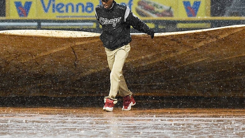 May 27, 2019; Chicago, IL, USA; A member of the grounds crew helps put a tarp on the field in a rain delay during the fifth inning of a game between the Chicago White Sox and the Kansas City Royals at Guaranteed Rate Field. Mandatory Credit: David Banks-USA TODAY Sports