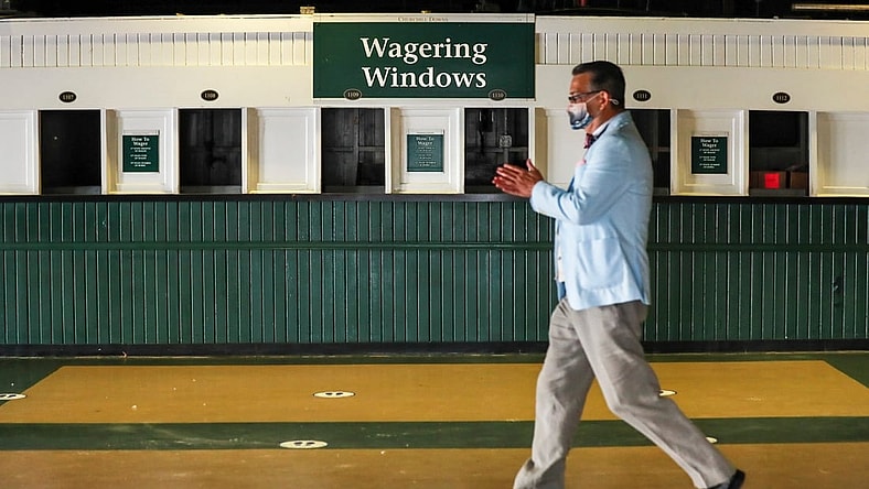 Sep 4, 2020; Louisville, Kentucky, USA;  A man rubs his hands with sanitizer as he walks past empty Wagering Windows at Churchill Downs on the 2020 Oaks Day Friday morning. No fans are allowed for Oaks nor the Kentucky Derby due to Covid-19: only horse owners, trainers, jockeys and family. Mandatory Credit: Matt Stone/Louisville Courier-Journal-USA TODAY NETWORK