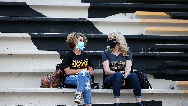 High school football fans wear masks during a national televised game at Saguaro High School. Mandatory Credit: Rob Schumacher/The Arizona Republic via USA TODAY NETWORK