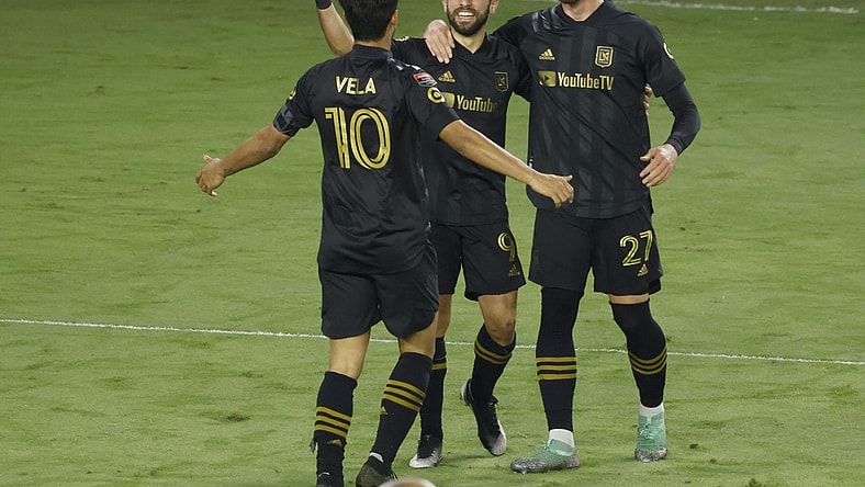 Dec 22, 2020; Orlando, Florida, USA; Los Angeles FC defender Tristan Blackmon (27) and forward Carlos Vela (10) congratulate forward Diego Rossi (9) on a goal against Tigres during the second half of the match at the 2020 SCCL final at Exploria Stadium. Mandatory Credit: Reinhold Matay-USA TODAY Sports