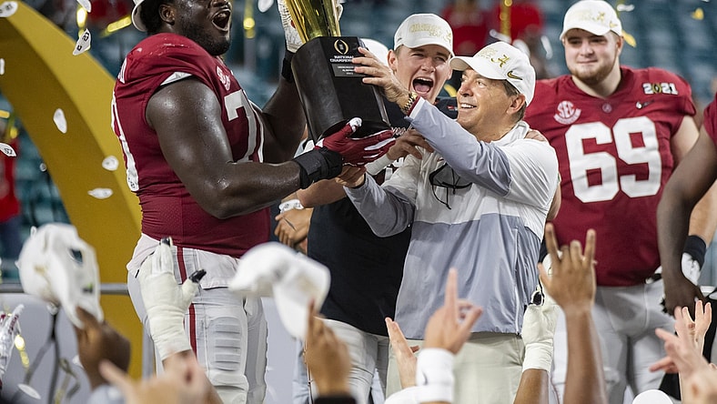 Jan 11, 2021; Miami Gardens, Florida, USA; Alabama Crimson Tide head coach Nick Saban and offensive lineman Alex Leatherwood (70) celebrates with the CFP National Championship trophy after beating the Ohio State Buckeyes in the 2021 College Football Playoff National Championship Game. Mandatory Credit: Mark J. Rebilas-USA TODAY Sports