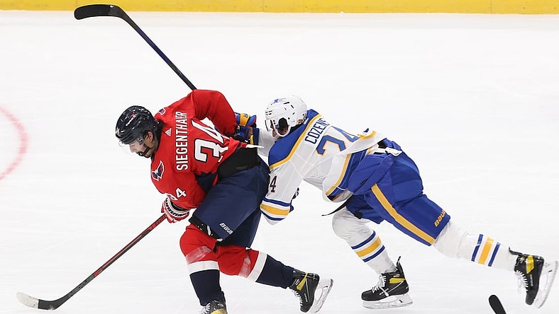 Jan 22, 2021; Washington, District of Columbia, USA; Washington Capitals defenseman Jonas Siegenthaler (34) battles for the puck with Buffalo Sabres center Dylan Cozens (24) in the second period at Capital One Arena. Mandatory Credit: Geoff Burke-USA TODAY Sports