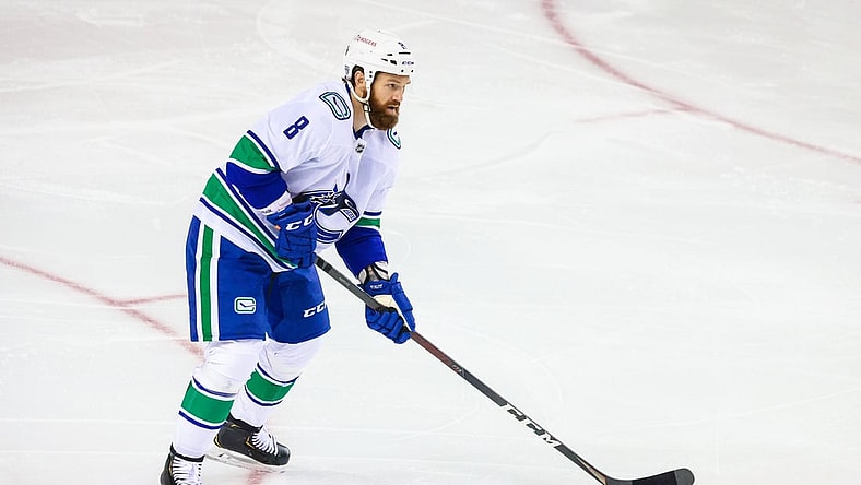 Feb 17, 2021; Calgary, Alberta, CAN; Vancouver Canucks defenseman Jordie Benn (8) controls the puck against the Calgary Flames during the first period at Scotiabank Saddledome. Mandatory Credit: Sergei Belski-USA TODAY Sports