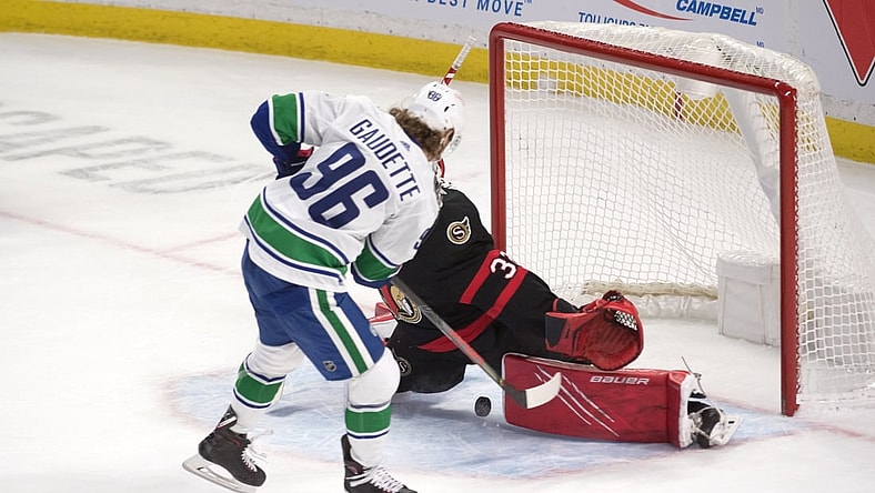 Mar 17, 2021; Ottawa, Ontario, CAN; Vancouver Canucks center Adam Gaudette (96) scores on Ottawa Senators goalie Filip Gustavsson (30) in a shootout at the Canadian Tire Centre. Mandatory Credit: Marc DesRosiers-USA TODAY Sports