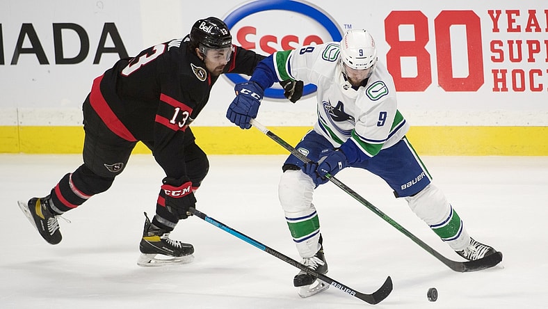Mar 17, 2021; Ottawa, Ontario, CAN; Ottawa Senators left wing Nick Paul (13) battles for the puck with Vancouver Canucks center J.T. Miller (9) in overtime at the Canadian Tire Centre. Mandatory Credit: Marc DesRosiers-USA TODAY Sports