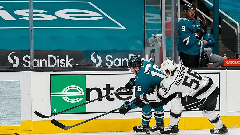 Mar 24, 2021; San Jose, California, USA;  San Jose Sharks center Ryan Donato (16) and Los Angeles Kings defenseman Kurtis MacDermid (56) reaches for the puck during the second period at SAP Center at San Jose. Mandatory Credit: Stan Szeto-USA TODAY Sports