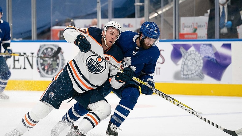 Mar 27, 2021; Toronto, Ontario, CAN; Toronto Maple Leafs center Alexander Kerfoot (15) battles for a puck with Edmonton Oilers center Connor McDavid (97) during the third period at Scotiabank Arena. Mandatory Credit: Nick Turchiaro-USA TODAY Sports
