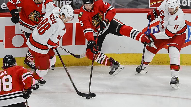 Apr 1, 2021; Chicago, Illinois, USA; Chicago Blackhawks defenseman Connor Murphy (5) battles for the puck with Carolina Hurricanes center Martin Necas (88) in the first period at United Center. Mandatory Credit: Kamil Krzaczynski-USA TODAY Sports