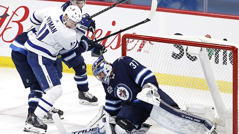 Apr 2, 2021; Winnipeg, Manitoba, CAN;  Winnipeg Jets goaltender Connor Hellebuyck (37) blocks a shot by Toronto Maple Leafs left wing Zach Hyman (11) in the first period at Bell MTS Place. Mandatory Credit: James Carey Lauder-USA TODAY Sports