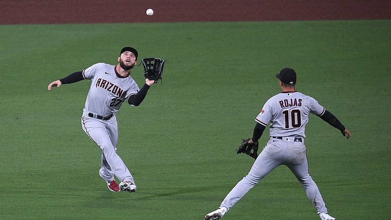 Apr 2, 2021; San Diego, California, USA; Arizona Diamondbacks left fielder Wyatt Mathisen (27) catches a fly ball hit by San Diego Padres catcher Luis Campusano (not pictured) as shortstop Josh Rojas (10) looks on during the second inning at Petco Park. Mandatory Credit: Orlando Ramirez-USA TODAY Sports