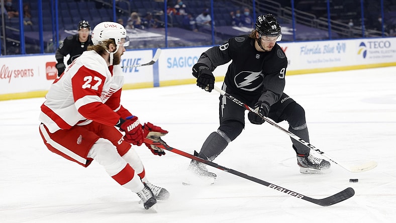 Apr 3, 2021; Tampa, Florida, USA; Tampa Bay Lightning defenseman Mikhail Sergachev (98) skates with the puck as Detroit Red Wings center Michael Rasmussen (27) defends during the first period at Amalie Arena. Mandatory Credit: Kim Klement-USA TODAY Sports