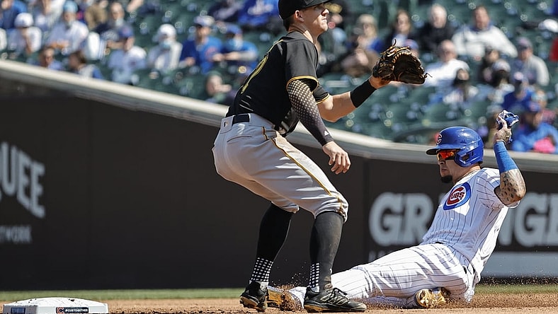 Apr 3, 2021; Chicago, Illinois, USA; Chicago Cubs shortstop Javier Baez (9) steals the second base as Pittsburgh Pirates shortstop Kevin Newman (27) waits for the ball in the second inning at Wrigley Field. Mandatory Credit: Kamil Krzaczynski-USA TODAY Sports
