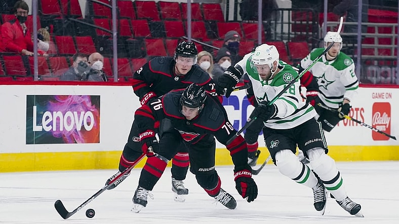 Apr 3, 2021; Raleigh, North Carolina, USA;  Carolina Hurricanes defenseman Brady Skjei (76) and Dallas Stars center Jason Dickinson (18) battle over the puck during the first period at PNC Arena. Mandatory Credit: James Guillory-USA TODAY Sports
